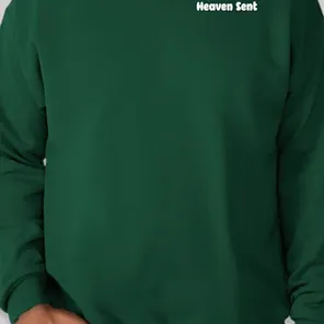 A person wearing a green sweatshirt with the words heaven sent on it.